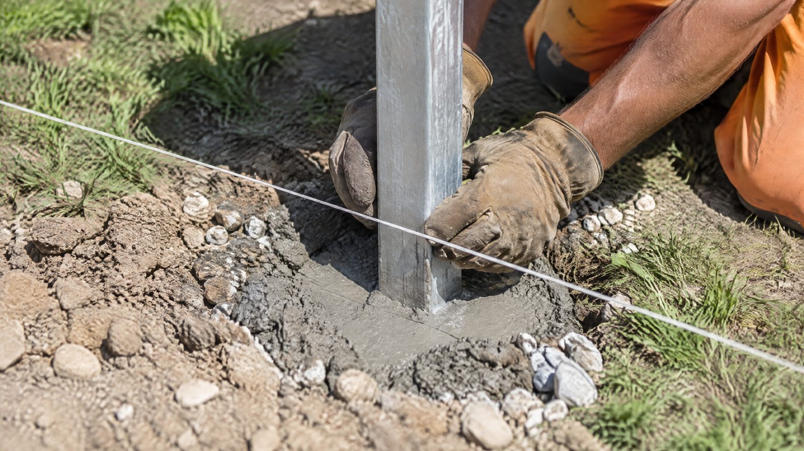 Ustawianie słupka ogrodzeniowego w betonie wzdłuż naciągniętego sznurka